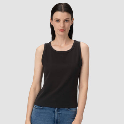 Woman wearing a black Laura tank top and blue jeans on a plain background