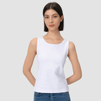 Model wearing white tank top against plain background