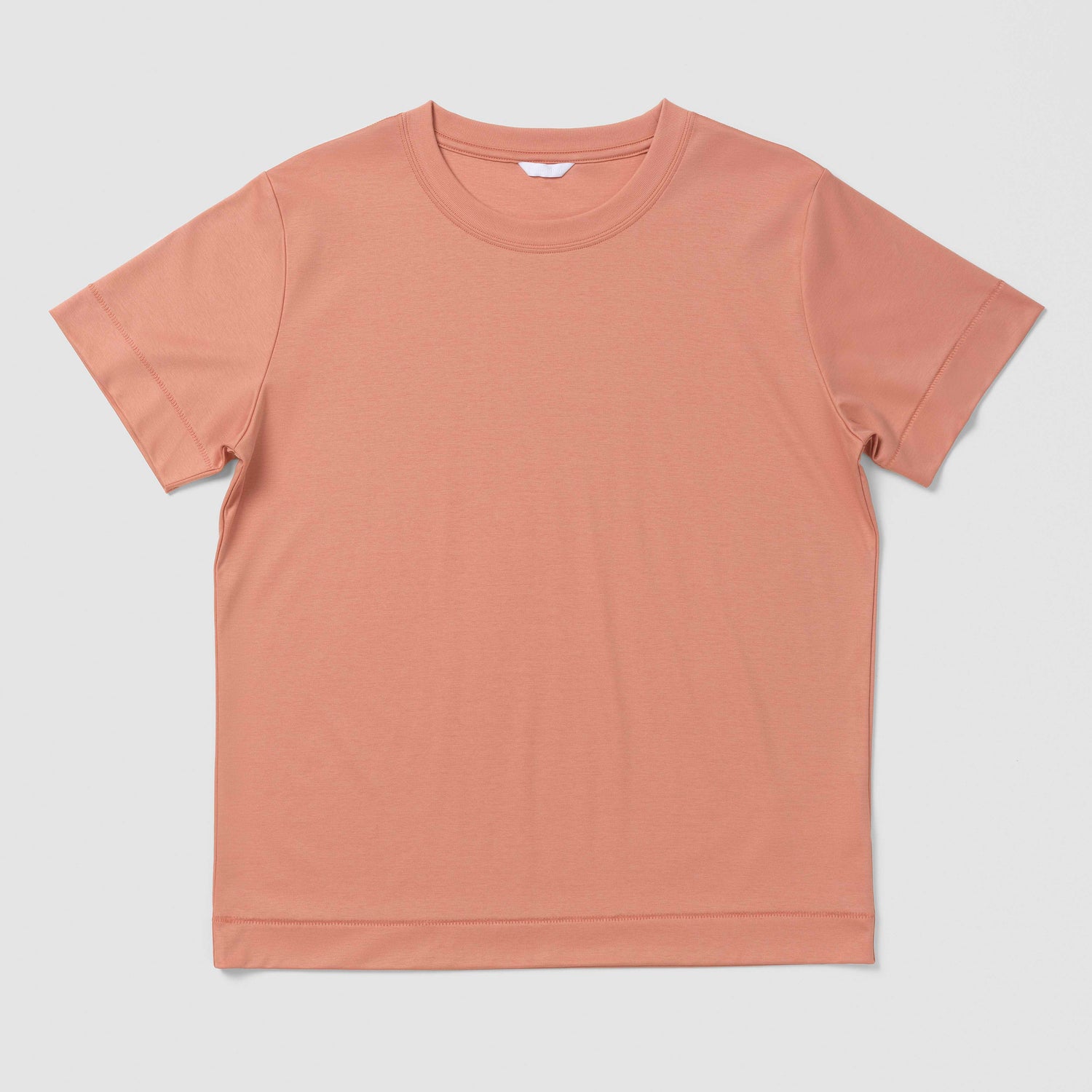 Plain orangy pink t-shirt on a light gray background
