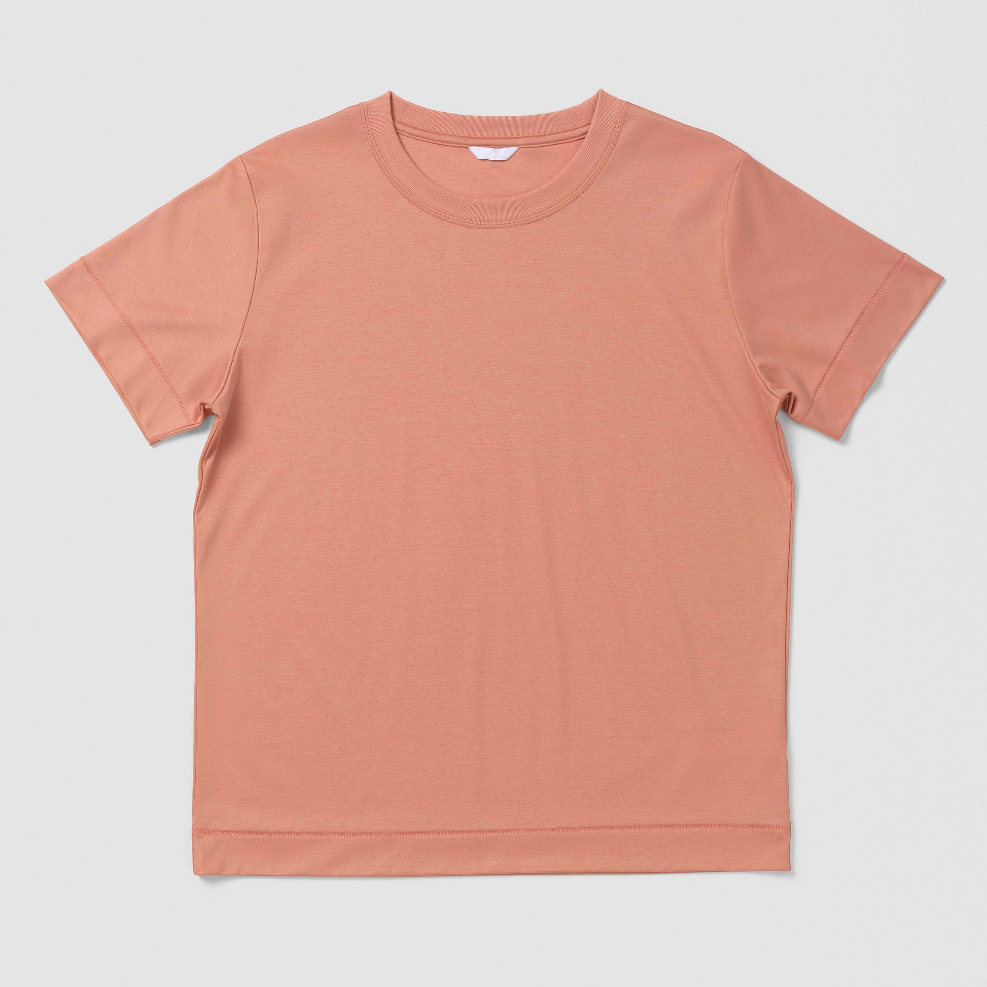 Plain orangy pink t-shirt on a light gray background