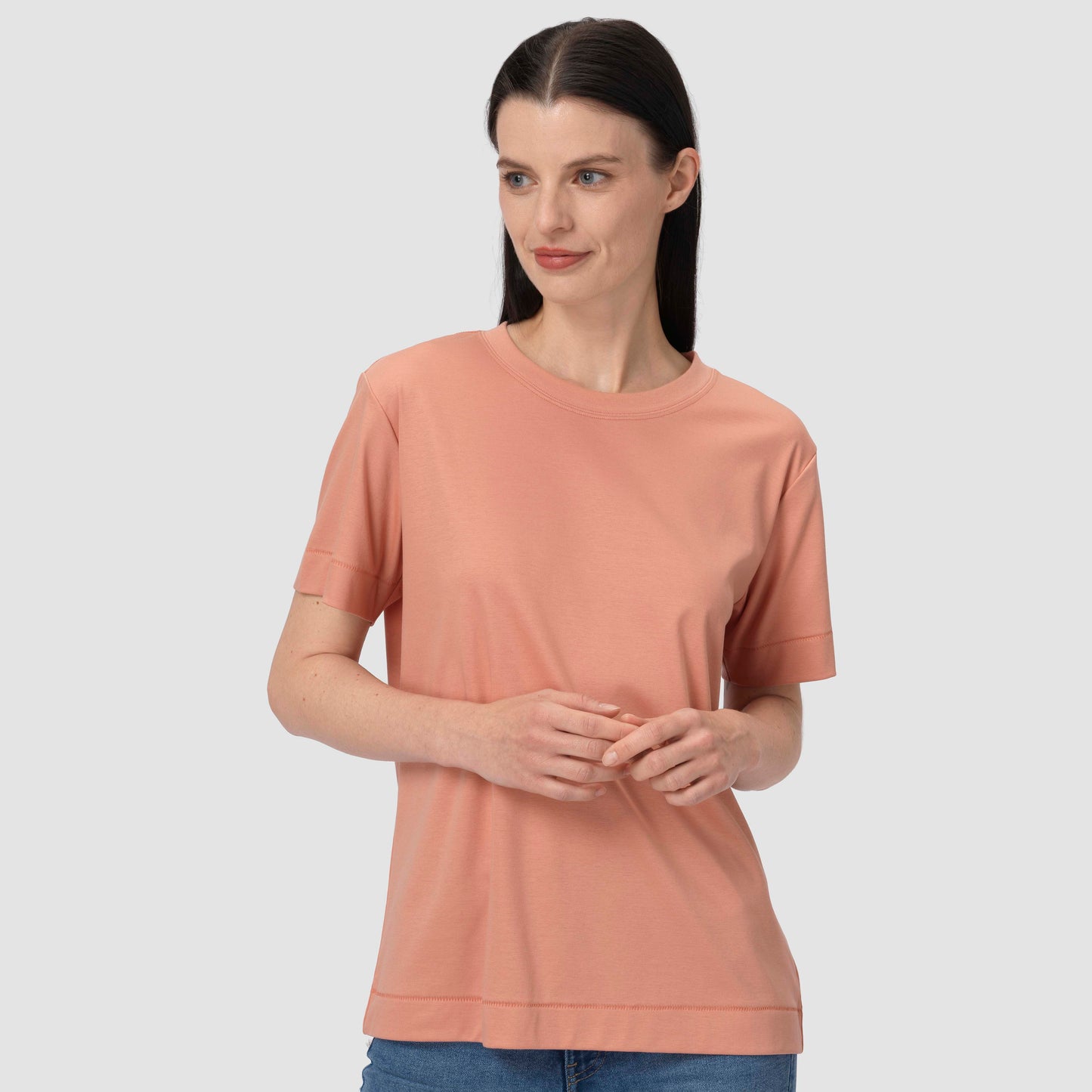 Woman wearing a pink t-shirt against a plain background