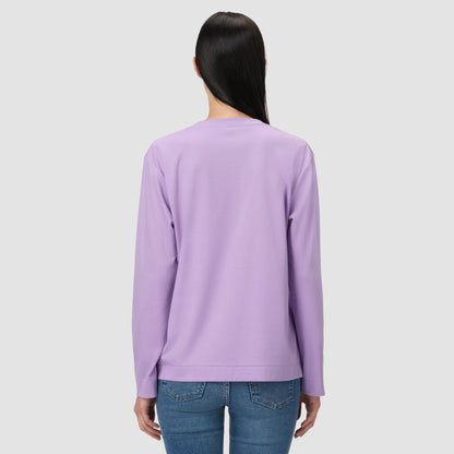 Une personne vêtue d'un t-shirt à manches longues violet sur fond gris clair