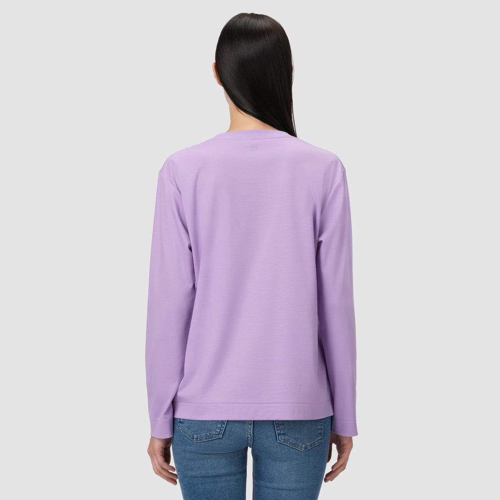 Une personne vêtue d'un t-shirt à manches longues violet sur fond gris clair