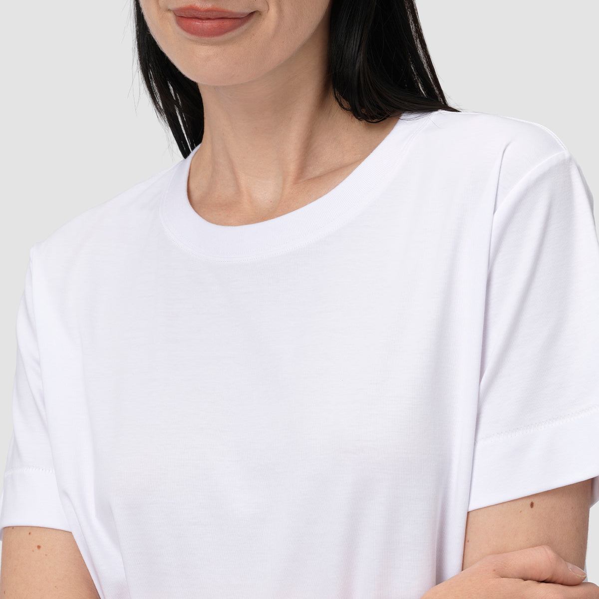 Person wearing a plain white t-shirt against a neutral background